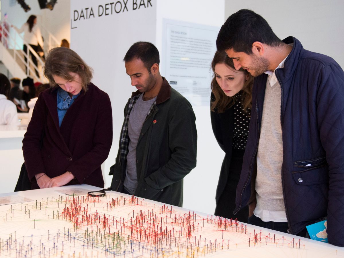 People interacting with the pieces of the Glass Room Exhibition